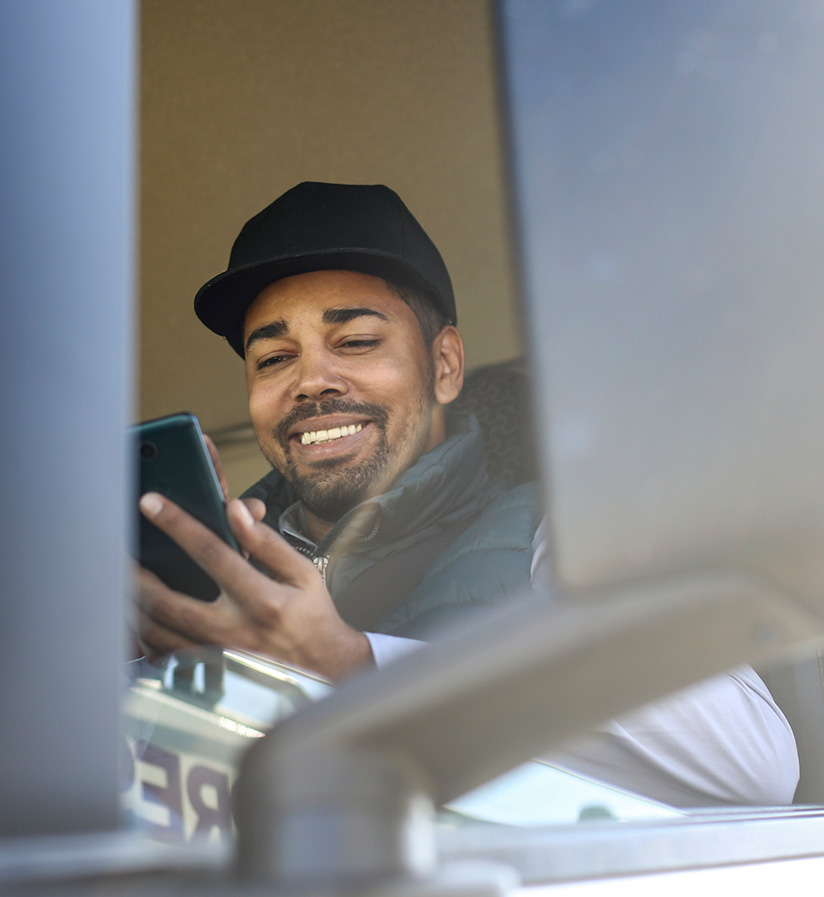 A truck driver using his cell phone to check for available loads.